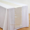 Elegant satin table runner in cream color draped across a white tablecloth.