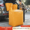 A woman is loading a large yellow waterproof storage bag into the trunk of a car.