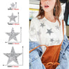 A woman models a white t-shirt decorated with silver glitter rhinestone star patches on the chest and shoulder area.