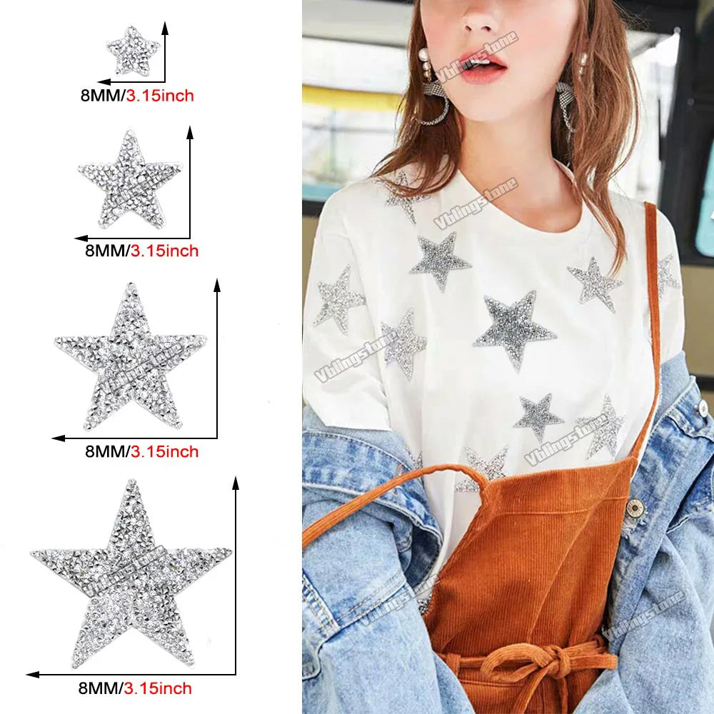 A woman models a white t-shirt decorated with silver glitter rhinestone star patches on the chest and shoulder area.