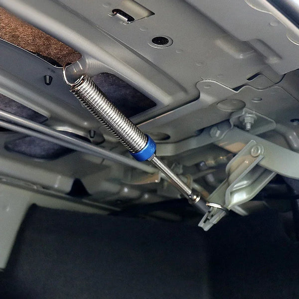A close-up view of an automatic car trunk lift spring mechanism inside a vehicle's interior panel.