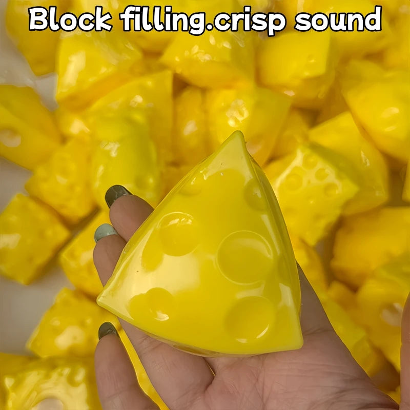 A hand holds a yellow, triangular fidget cube with dimples against a background of similar yellow pieces.