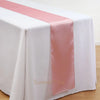 Elegant satin pink table runner draped across a white tablecloth.