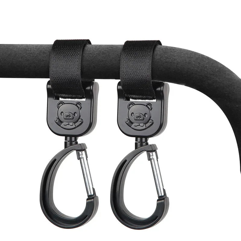 Black rotating hooks designed for hanging bags and essentials on a stroller bar.