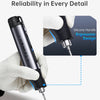 A hand holds a black cordless soldering iron with a silicone handle, demonstrating its ergonomic design.
