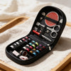A black compact travel sewing kit with various tools and threads is displayed on a wooden tray.