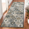 A rectangular vintage bohemian trellis runner rug with gray and beige patterns placed on a wooden floor.