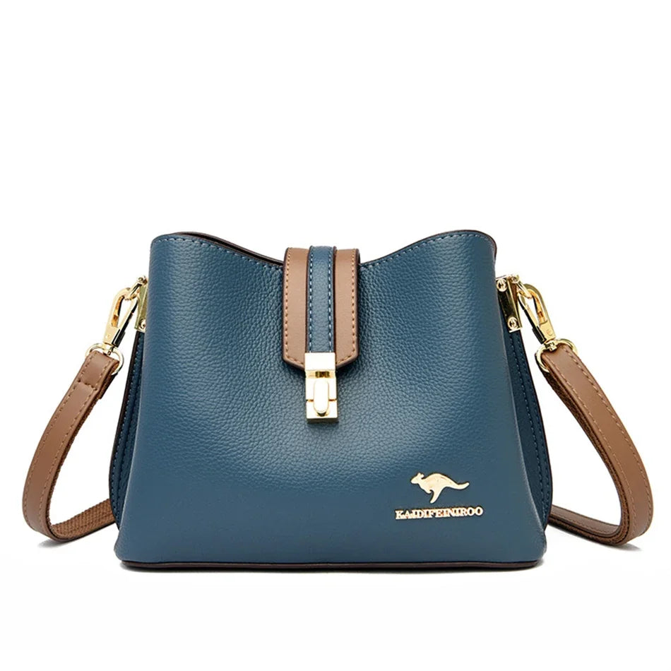 A dark blue leather shoulder bag with gold hardware and a brown strap.