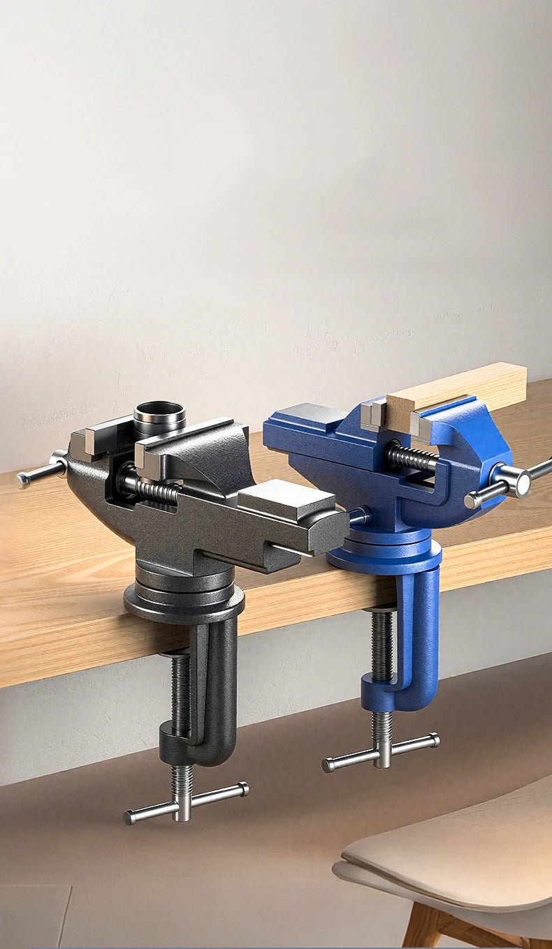 A pair of silver and blue clamp-on vises used to secure objects on a wooden workbench.