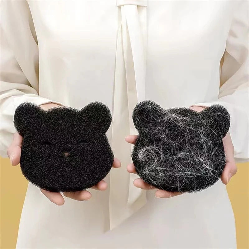 Une paire de tampons réutilisables pour enlever les poils d'animaux noirs, tenus par une personne vêtue d'un chemisier blanc.