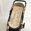 A brown and black stroller with a cream cushion featuring small cartoon bears.