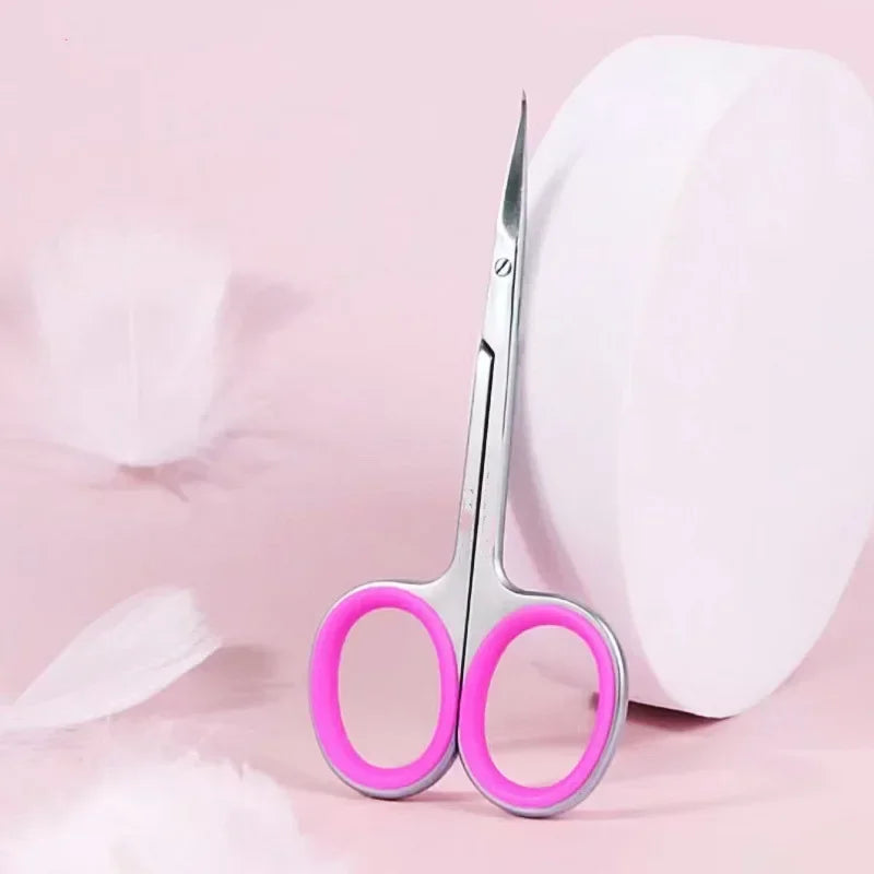 Pair of professional stainless steel cuticle scissors with curved blades resting on a pink background.