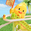 A yellow duck toy is shown climbing a green plastic stair structure outdoors.
