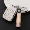 A white TPU smart key fob cover with a gold clip attached to a leather strap and a silver keyring.