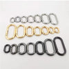 Eine Sammlung ovaler federförmiger O-Ring-Schnallen in Silber, Gold und Schwarz.