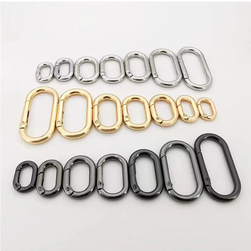 Eine Sammlung ovaler federförmiger O-Ring-Schnallen in Silber, Gold und Schwarz.