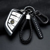 A silver personalized phone number keychain with a braided black leather rope and metal clasp.