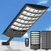 A black solar flood light with multiple LED panels is mounted on a pole, ready for outdoor lighting.
