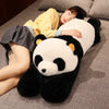 A person is relaxing on a couch with a giant soft panda plush toy, which has long arms, resting beside them.