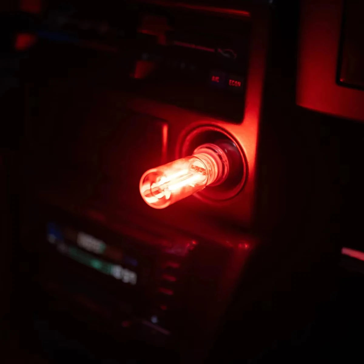 Nahaufnahme einer USB-Touch-dimmbaren LED-Glühfaden-Nachtleuchte, die rot in einem dunklen Gerät leuchtet.