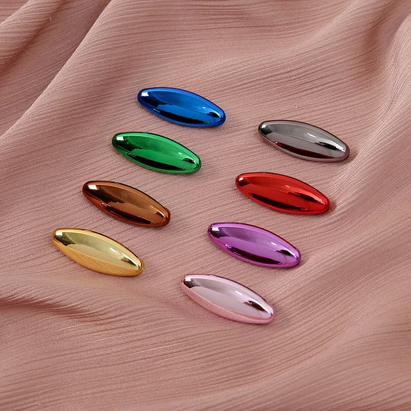 A set of eight solid color scarf pins in various shades including blue, green, silver, red, and purple, displayed on pink fab