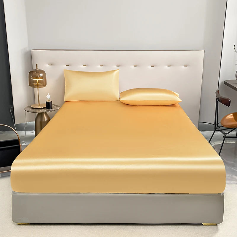 Luxuriöse goldgelbe, eng anliegende Matratzenbezug auf einem Bett mit weißem gepolstertem Kopfteil.