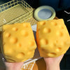 Two yellow giant squeeze playful cheese fidget toys are held against a light background.