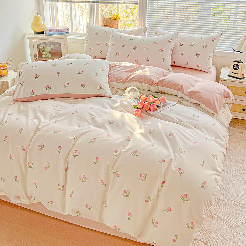 A floral duvet cover set in soft pink and cream tones displayed on a bed with natural light.