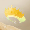 A yellow adjustable baby bath shampoo shield cap with ear protection is shown against a light background.