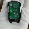A close-up view of a replacement remote key electronic module with a green circuit board held in a hand.