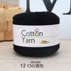 A skein of black cotton yarn labeled Cotton Yarn 100g, shown on a wooden surface.
