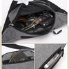 A gray canvas waist pack with multiple zippered pockets and leather accessories inside.