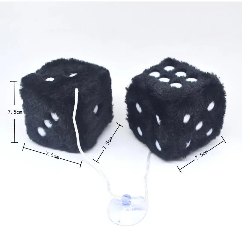 A black plush velvet dice with white dots and a string attached, shown against a white background.