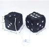 A black plush velvet dice with white dots and a string attached, shown against a white background.