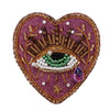 A heart-shaped patch featuring a detailed eye design made of gold and white beads on a purple fabric background.