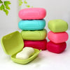 A stack of colorful, leak-proof portable soap holders in pink, blue, and green, with one open showing a white bar of soap.
