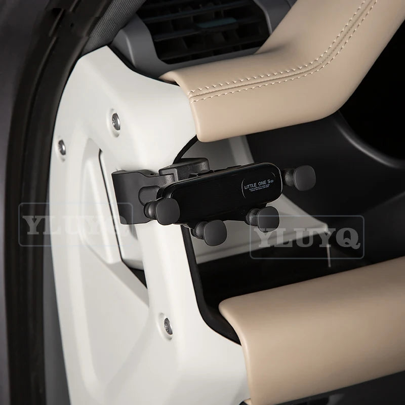 A black magnetic car phone mount with a cup holder base is shown in a white and beige interior setting.