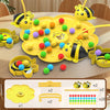 A yellow board game featuring bees and colorful balls is displayed on a wooden table.
