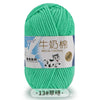 A ball of bright green milk cotton blend yarn with a label in Chinese and English.