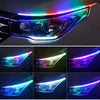 Close-up view of a car headlight featuring bright blue and green RGB LED daytime running lights.