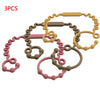 Three silicone pacifier clips or teethers in various colors including pink, beige, and gray.