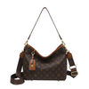 A brown canvas tote bag with a gold chain strap and leather accents featuring a classic retro pattern.