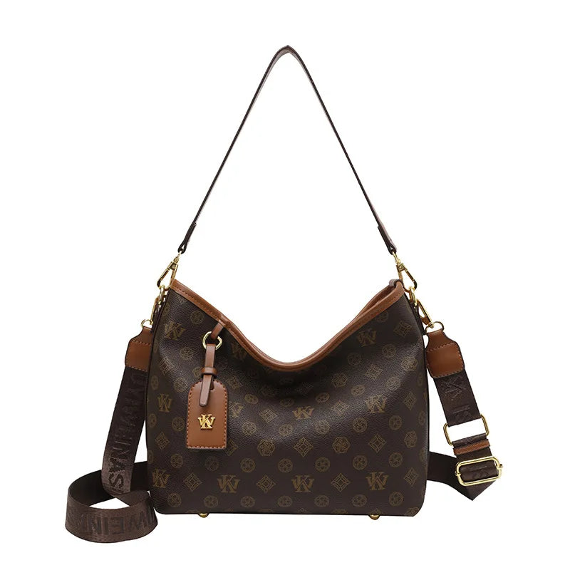 A brown canvas tote bag with a gold chain strap and leather accents featuring a classic retro pattern.