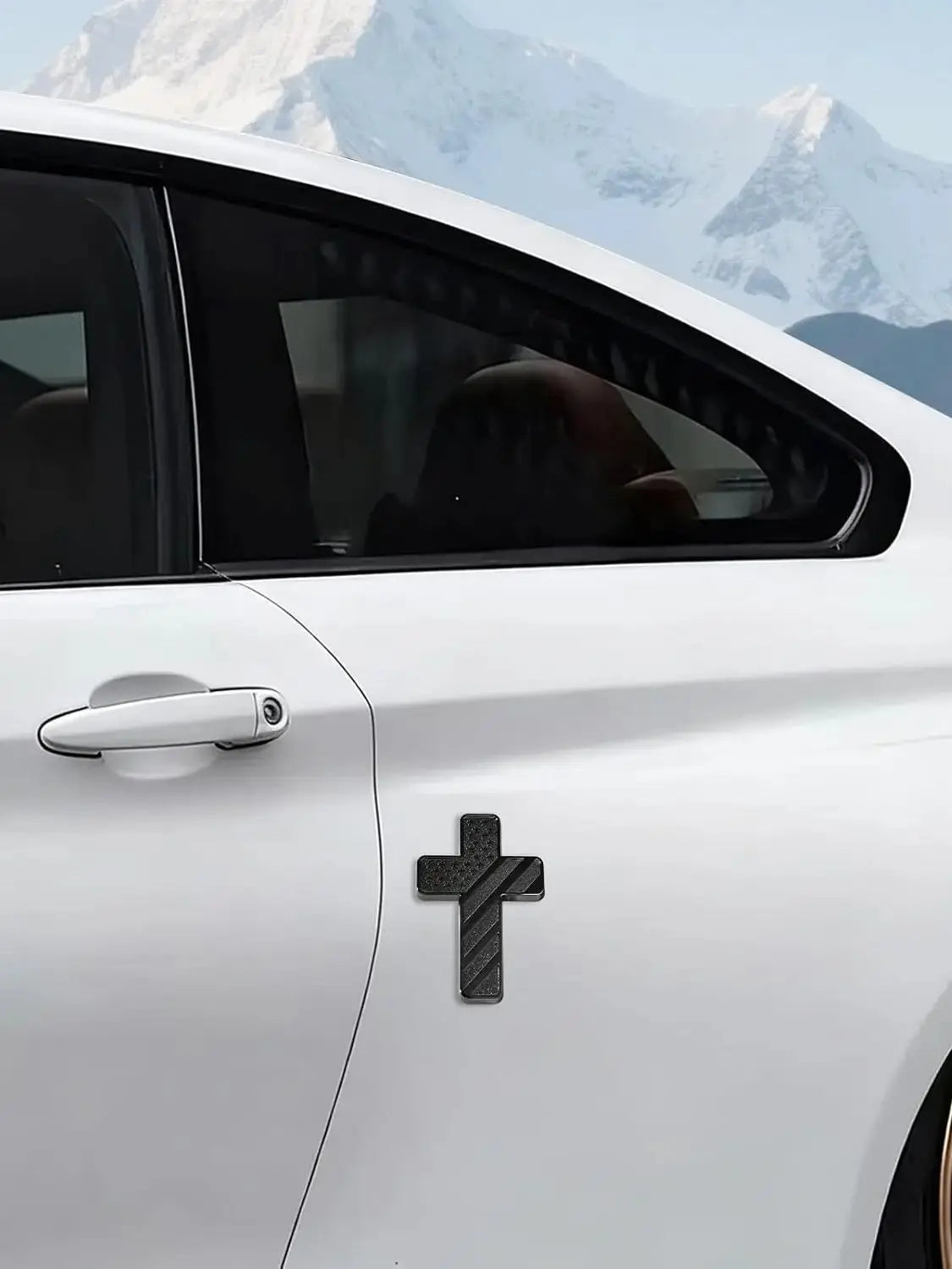 A close-up of a white car door showing a black cross emblem on the side panel.