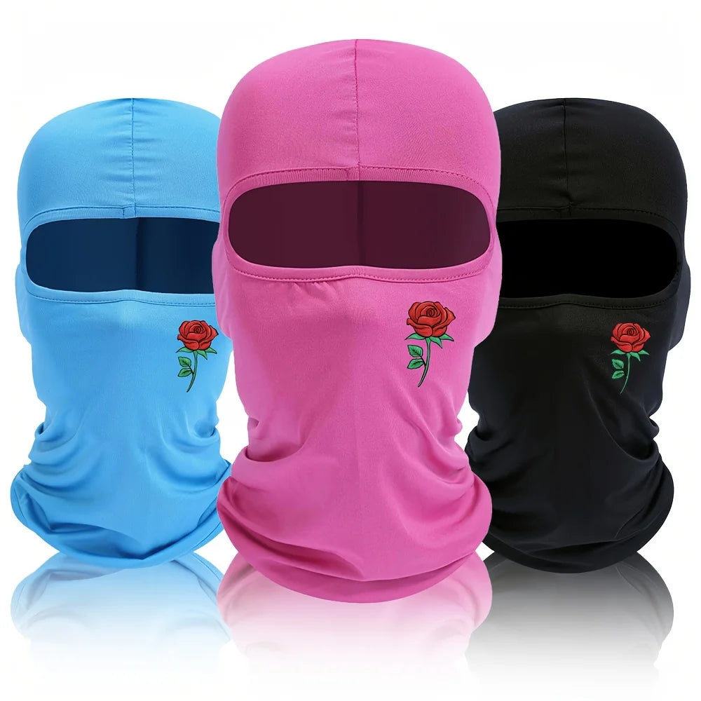 Three balaclavas in blue, pink, and black with floral designs displayed side by side.