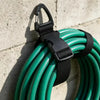 A coil of green heavy duty extension cords bundled together with black plastic organizers.