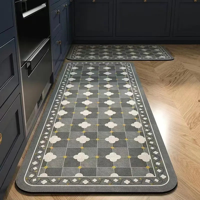 A rectangular gray kitchen rug with a classic Persian print and yellow accents placed on a light wood floor.