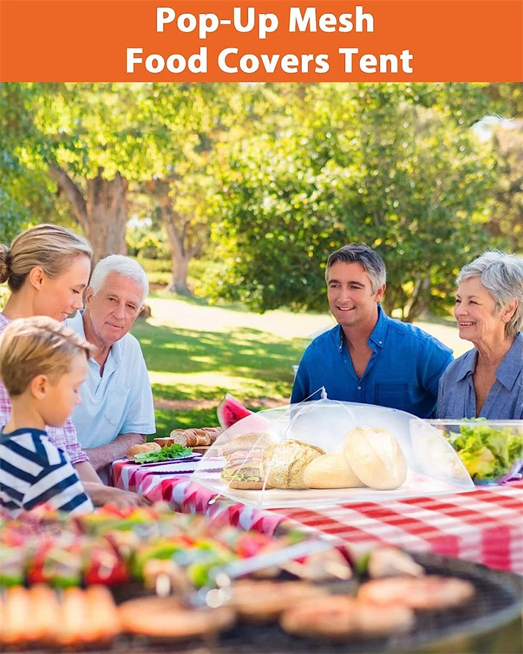 A family enjoying an outdoor meal under a pop-up mesh food covers tent with various foods displayed.