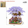 A detailed micro building block model of a pink sakura treehouse with purple flowers and an LED light.
