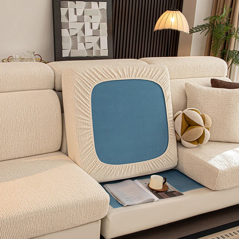 Funda de asiento de sofá elástico beige con panel de acento azul y detalles de fibra natural.
